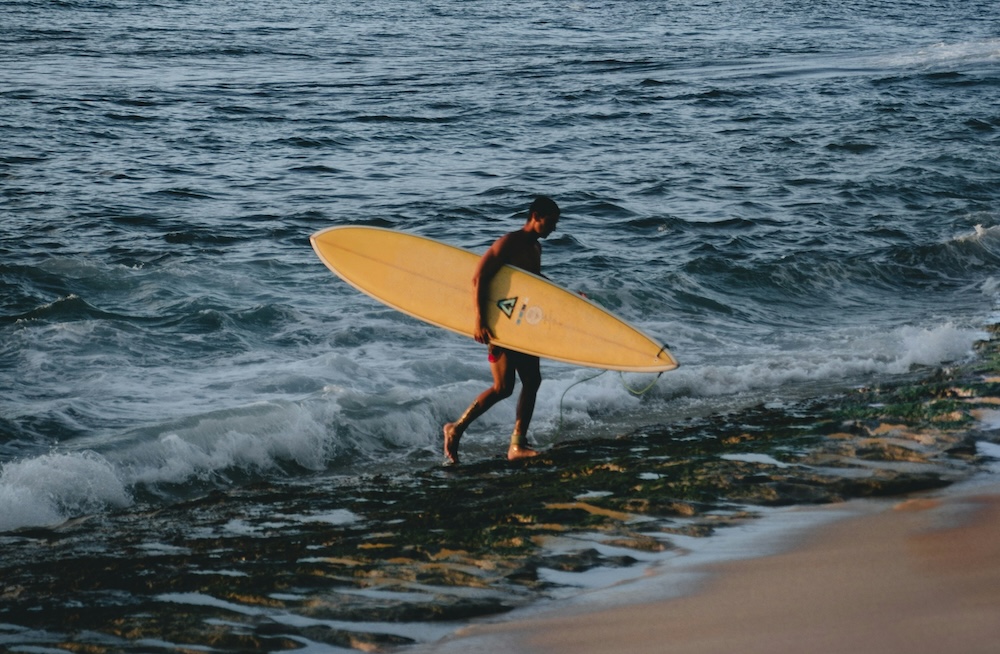 Man holding surfboard on the beach